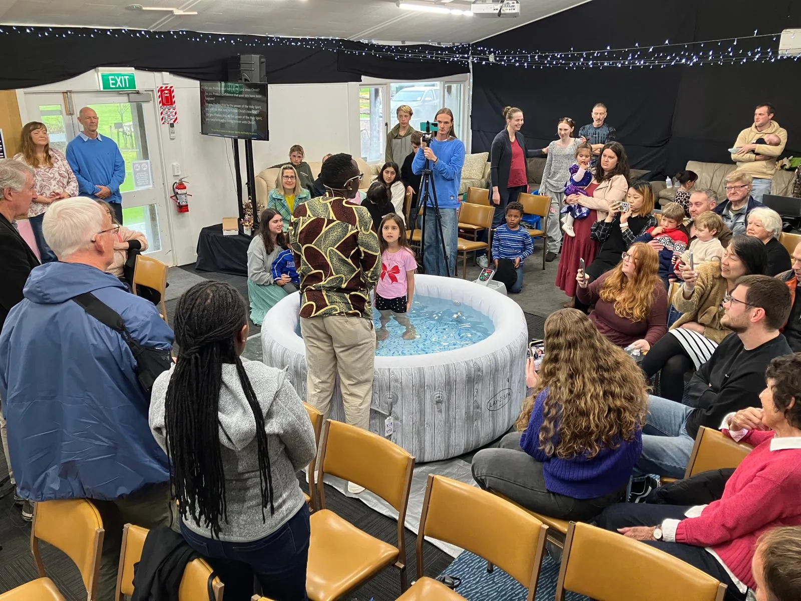 The congregation gathered around a baptism at a Sunday service